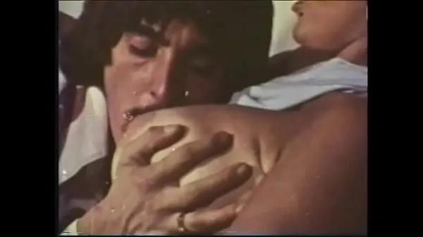 XXX A mustachioed dude with long sideburns caresses an experienced blonde with huge buckets in a 70s video samlede film