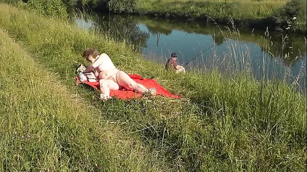 Celkem XXX filmů: MILF sexy Frina on river bank undressed and sunbathes naked. Random man fisherman watching for her, and in the end decided to join naked woman. Wild beach. Nudist beach. Public nudity. Public exposure. Naked in public
